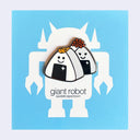 Enamel pin of 2 onigiri rice balls, one has a tiny fish atop it and the other has roe. They both have cute, cartoon smiles and a sparkle on their seaweed wrapping. On blue "Giant Robot" backing board.