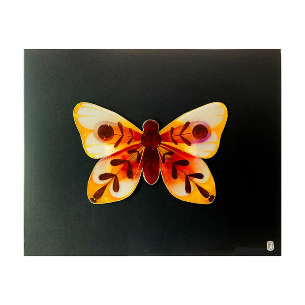 Painting on cut out paper of a butterfly with burgundy, yellow and deep orange coloring. Its wings have abstract leaf shape patterns with a circle in the center of each top wing. Butterfly is mounted on black paper.