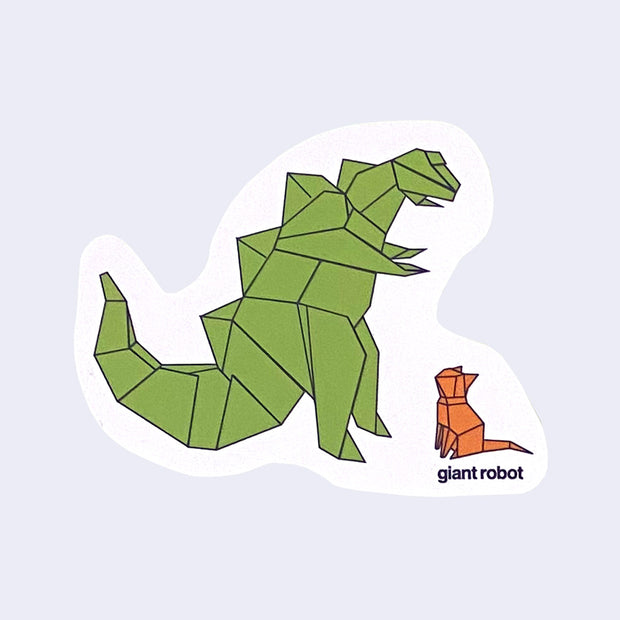 White die cut sticker of a large origami godzilla, standing with its short arms out and looking down at an orange origami cat, who looks up at the kaiju. Below the cat reads "giant robot" in small black font. 