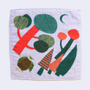 Light purple square towel with imagery of stylized green and red trees, under a small green crescent moon. A fluffy brown owl stands under the trees.