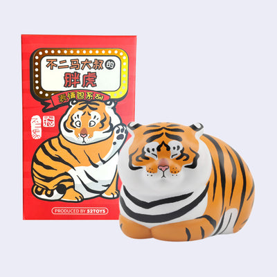 Figure of a chubby tiger sitting next to its product packaging.