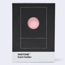 A Pantone Card holder in its retail packaging, featuring a minimalist black box with a pink circular cutout and a white bottom band labeled 'PANTONE Card holder'.