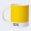A ceramic mug designed to look like a Pantone color swatch, featuring a solid yellow body with a white bottom band printed with 'PANTONE Yellow 012'.