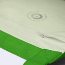Close-up of a cream-colored zippered pouch or bag with a bright green fabric trim and a gray printed logo reading 'COPENHAGEN DESIGN'.