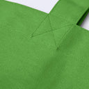 Close-up of a bright green woven fabric tote bag showing the texture of the canvas material and a stitched strap attachment.