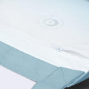 Close-up of a white zippered pouch or bag with a light blue fabric trim and a subtle circular logo near the top.