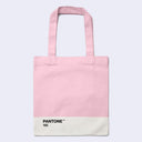 A light pink canvas tote bag with a white bottom panel printed with the text 'PANTONE 182' in black, set against a light gray background.