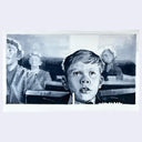 Black and white image of a young boy with a surprised expression, surrounded by other figures.