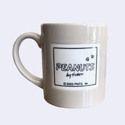Gray mug with 'PEANUTS by Schulz' logo on a light gray background