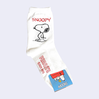 White crew length socks with Snoopy and Peanuts branding on the side and bottom of foot.