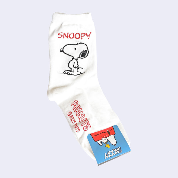 White crew length socks with Snoopy and Peanuts branding on the side and bottom of foot.