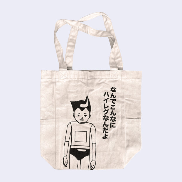 Cream tote bag with a black line art drawing of a boy who looks part robot, with a square over his stomach and lines on his joints. He wears briefs and has pointed hair, akin to Astroboy. Kanji is written on the side.
