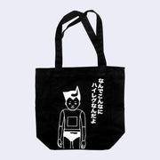 Black tote bag with a white line art drawing of a boy who looks part robot, with a square over his stomach and lines on his joints. He wears briefs and has pointed hair, akin to Astroboy. Kanji is written on the side.