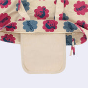 Close up of the top of a tote bag, with a small cream colored pouch inside the tote bag.