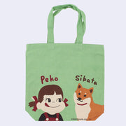 Green  tote bag featuring 2 illustrations at the bottom. One is Peko, a small girl in red overalls with pigtails tied in red ribbons. The other is a tan and white Shiba Inu dog. "Peko" is written above the girl and "Sibata" above the dog.