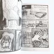 Open comic book with black and white illustrations on a white background