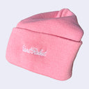 Side view of a pink beanie with white embroidered cursive that reads "giant robot"