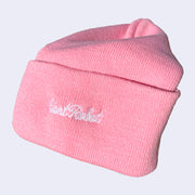 Side view of a pink beanie with white embroidered cursive that reads "giant robot"