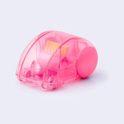 Pink plastic semi transparent dome shaped car, with small wheels and a brush mechanism inside, which turns with the wheels and rotates the bristles like a sweeper.