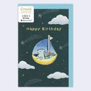 Birthday card with a cartoon bear on a moon-shaped boat, surrounded by clouds and stars, featuring the brand 'Creald'.