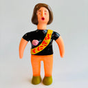 Toy figure with a black shirt and orange pants on a gray background