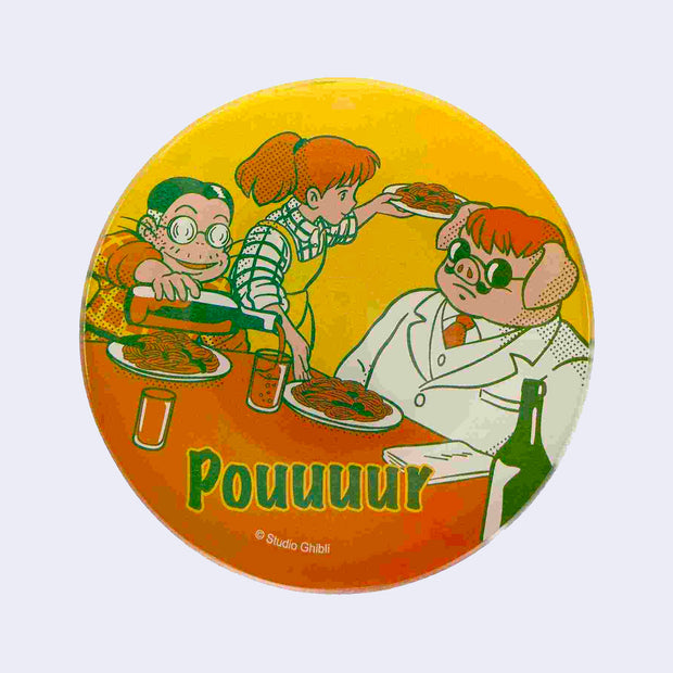Small, circular glass plate featuring a bright vintage style illustration in yellow, orange and green of a scene from Porco Rosso. A pig and a man sit at a table, while a woman places food down. "Pouuuur" is written on the plate.