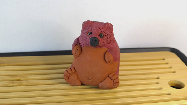 Video of water being poured on a sculpture of a brown bear, which then turns partially yellow.