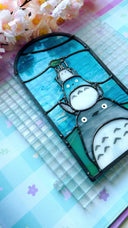 Stained glass panel with Totoro characters from Studio Ghibli, stacked atop of one another.