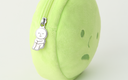 Close up of silver zipper accessory on a round plush pouch shaped like Smiski's head. The zipper is of Smiski sitting with their knees pulled into their chest.