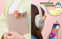 Example photo showing Mofusand Hipper figures being attached to items, such as headphones, phones, and a journal.