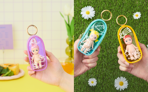 Promo photos for Sonny Angel My Bestie Case - 3 clear oval shaped cases with white doodles on the exterior, each holding a Sonny Angel inside.