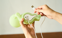 Person holding the Smiski touch light upside down, showing its USB cable.
