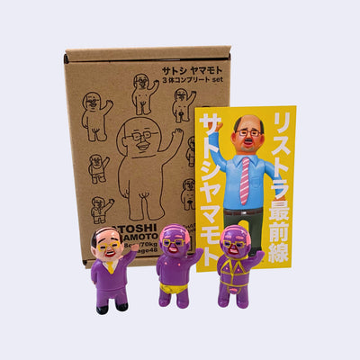 Set of 3 small vinyl figures of little business men. One wears a purple suit and waves. Another has pink hair, purple skin and wears a yellow briefs. The final figure has pink hair, purple skin and wears yellow bondage type attire.