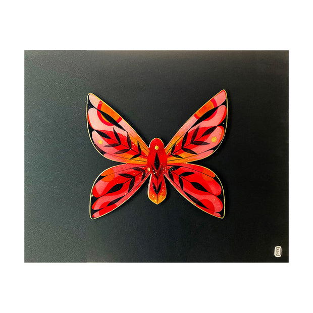 Painting on cut out paper of a butterfly with red, orange and black patterned wings with pointed edges. Butterfly is outline in gold, has gold specks on it and is mounted on black paper.