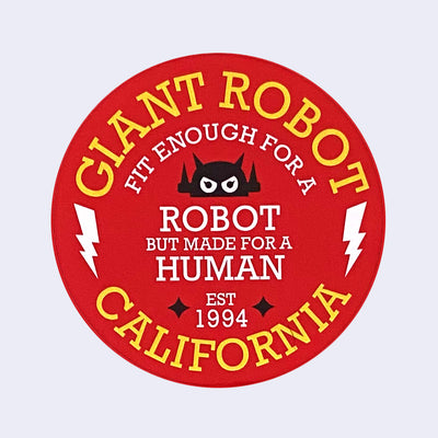 Red circle sticker with yellow and white text and black illustrative elements. Reads "Giant Robot" on top, "fit enough for a robot but made for a human" in the middle and "California" on the bottom. A small robot logo is in the middle and a lightning bolt on the left and right side.