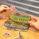 Model train set with cherry blossom trees on a wooden surface