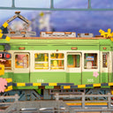 Model train set with green and yellow train car on a track