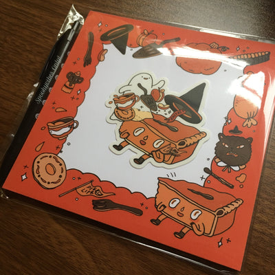 Notepad set with orange and black autumn themed graphics and food illustrations. Comes with a sticker and pen.