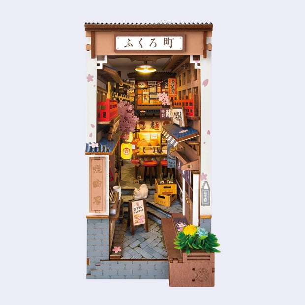Miniature model of a Japanese street scene with shops and lots of boxes and signs.