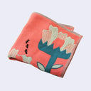 Salmon pink square handkerchief with 3 large stylistic white flowers with thick green stems, a small line of ants walks nearby.