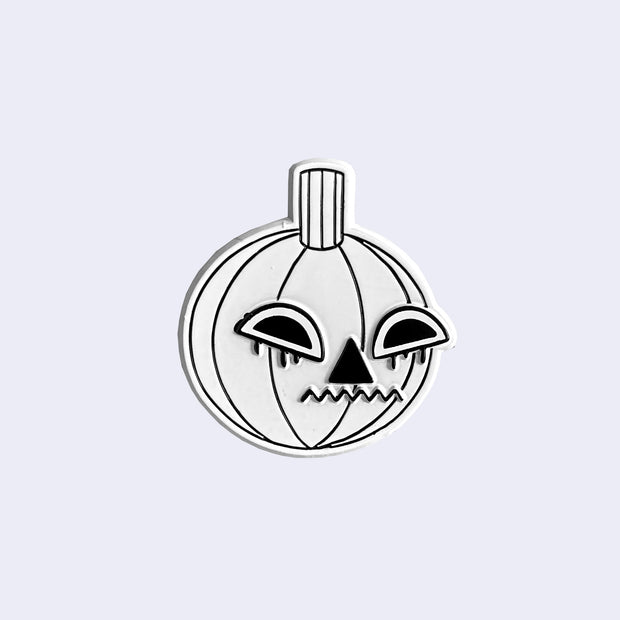 Die cut enamel pin of a white pumpkin with a jack o lantern style expression of dismay.