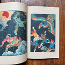 Open book displaying colorful illustrations of mythical creatures and characters on a wooden surface.