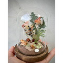 Mixed media sculpture diorama in a glass cloche. A school of orange and black speckled angel fish swim around cut paper leaves. Snails sit on the bottom of the scene.