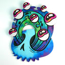 Painted flat wood sculpture of a blue skull with a circular wave of green and blue water coming out of its eye sockets. On the wave are several pink eyeballs.