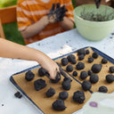Children playing with soil on a tray outdoors