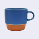 Blue mug with brown bottom on a light gray background