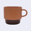 Brown ceramic mug with a dark brown base on a light gray background