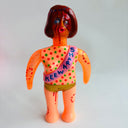 Colorful figurine with a polka dot shirt and text on a light gray background