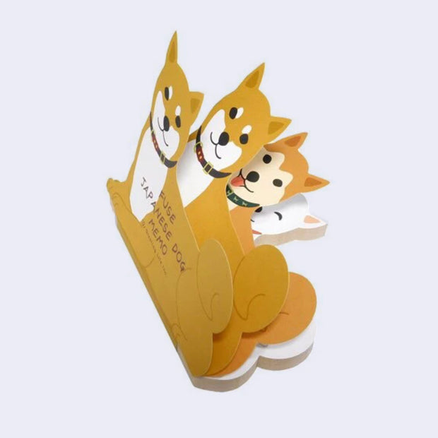 Die cut memo pad of Shiba Inu dogs being leafed through, to show 3 different designs of Shiba Inus.