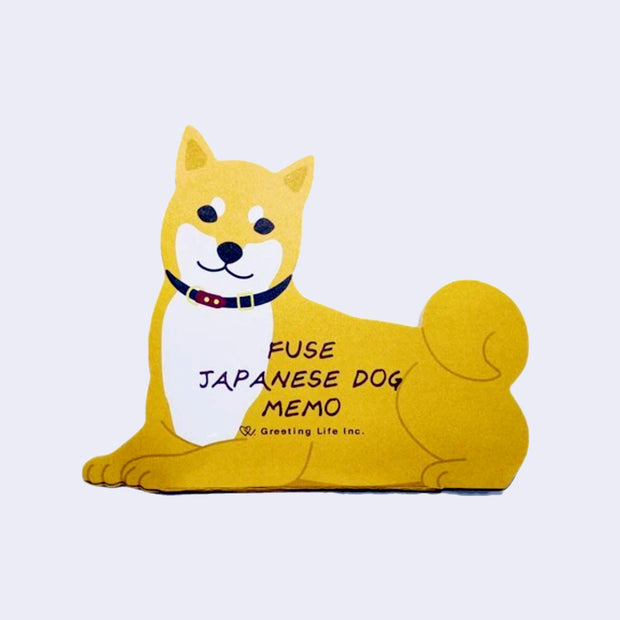 Die cut memo pad of a cartoon shiba inu, sitting and smiling with navy blue collar.